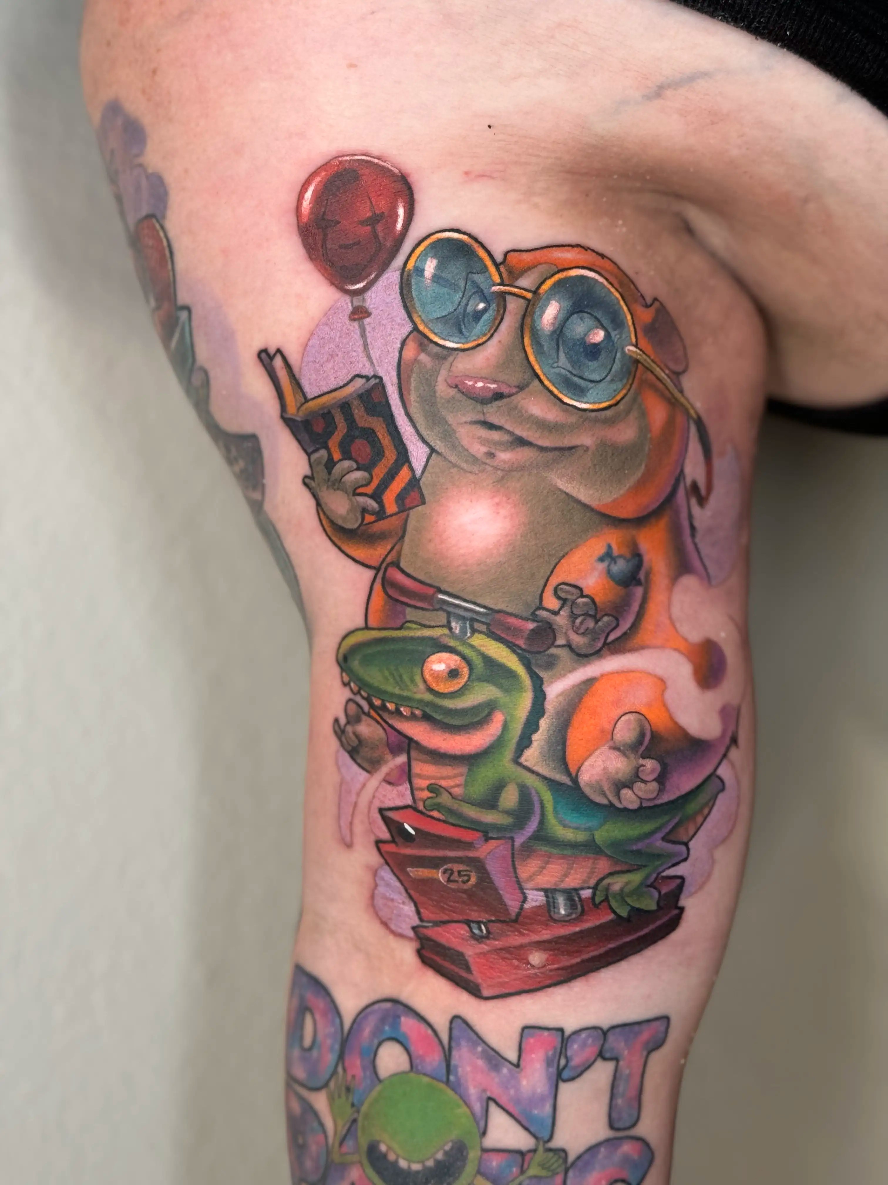 New school tattoo of a hamster riding a coin operated kiddy ride