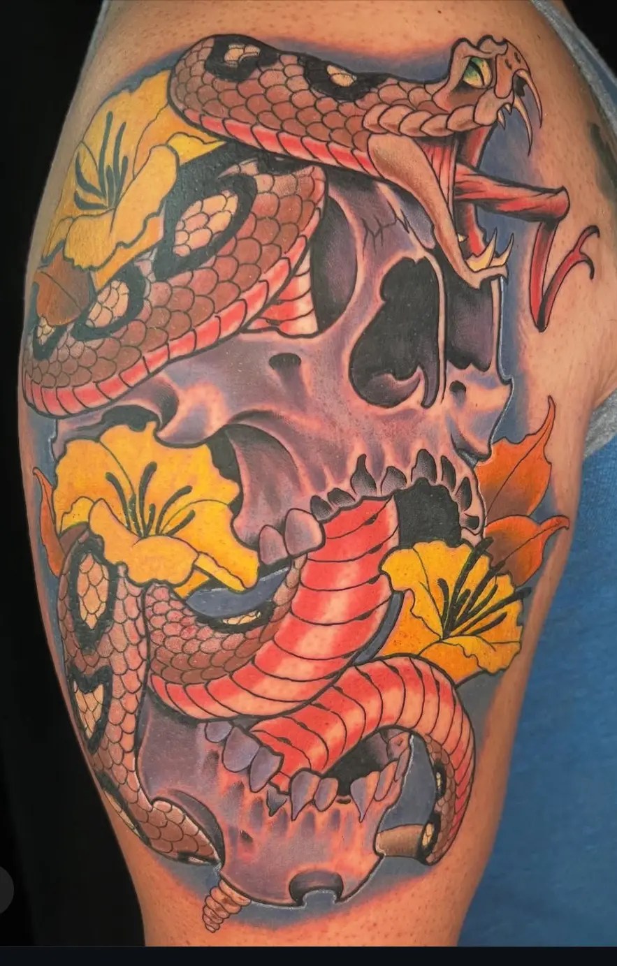 Colorful tattoo of a snake, skull and flowers