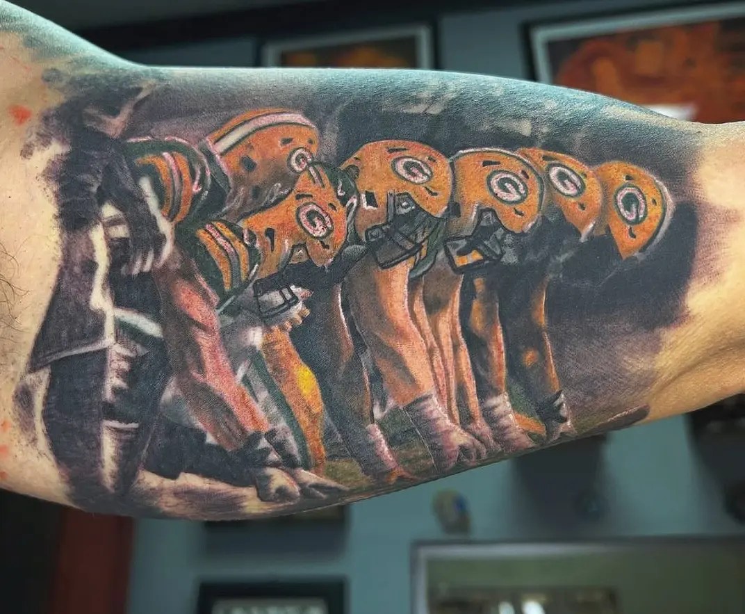 Colorful detailed tattoo of the Green Bay Packers playing football