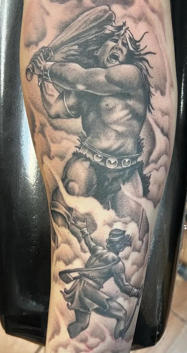 Black and grey tattoo portraying the scene of David and Goliath