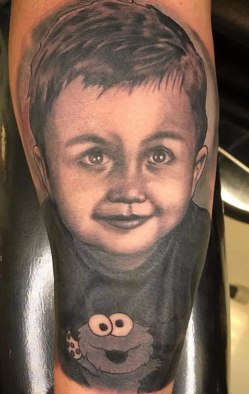 Black and grey portrait tattoo of a young boy