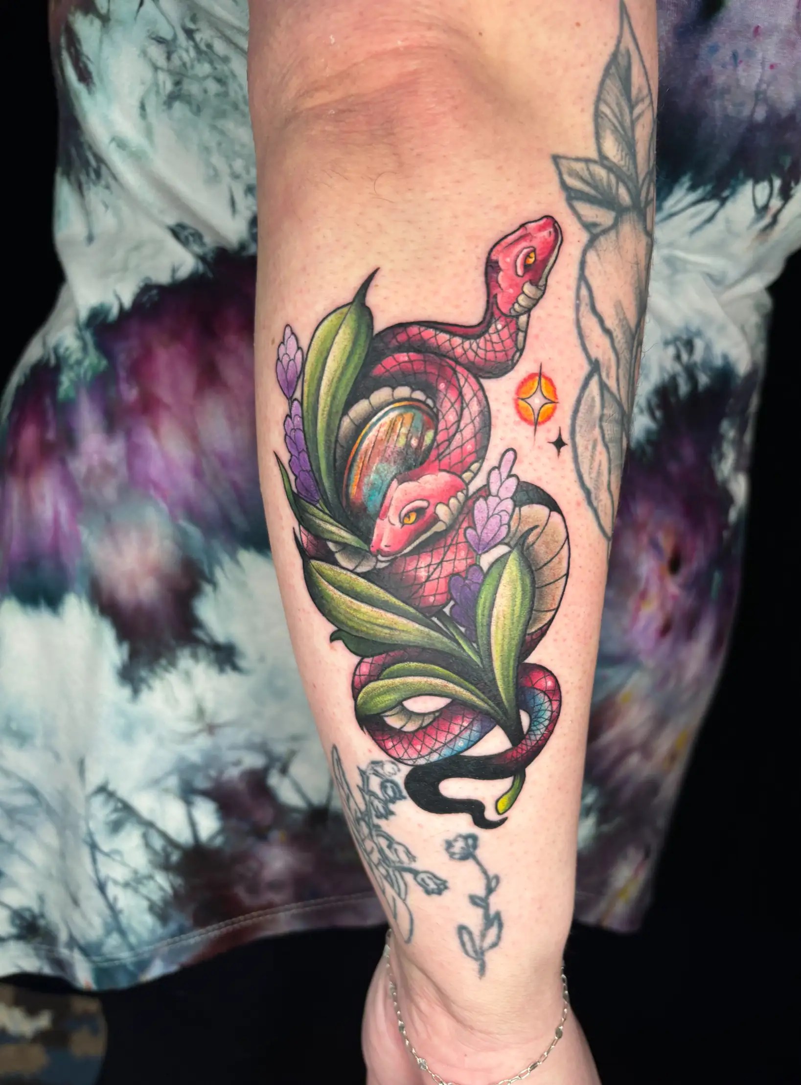 Colorful tattoo of a two headed snake with a flower plant