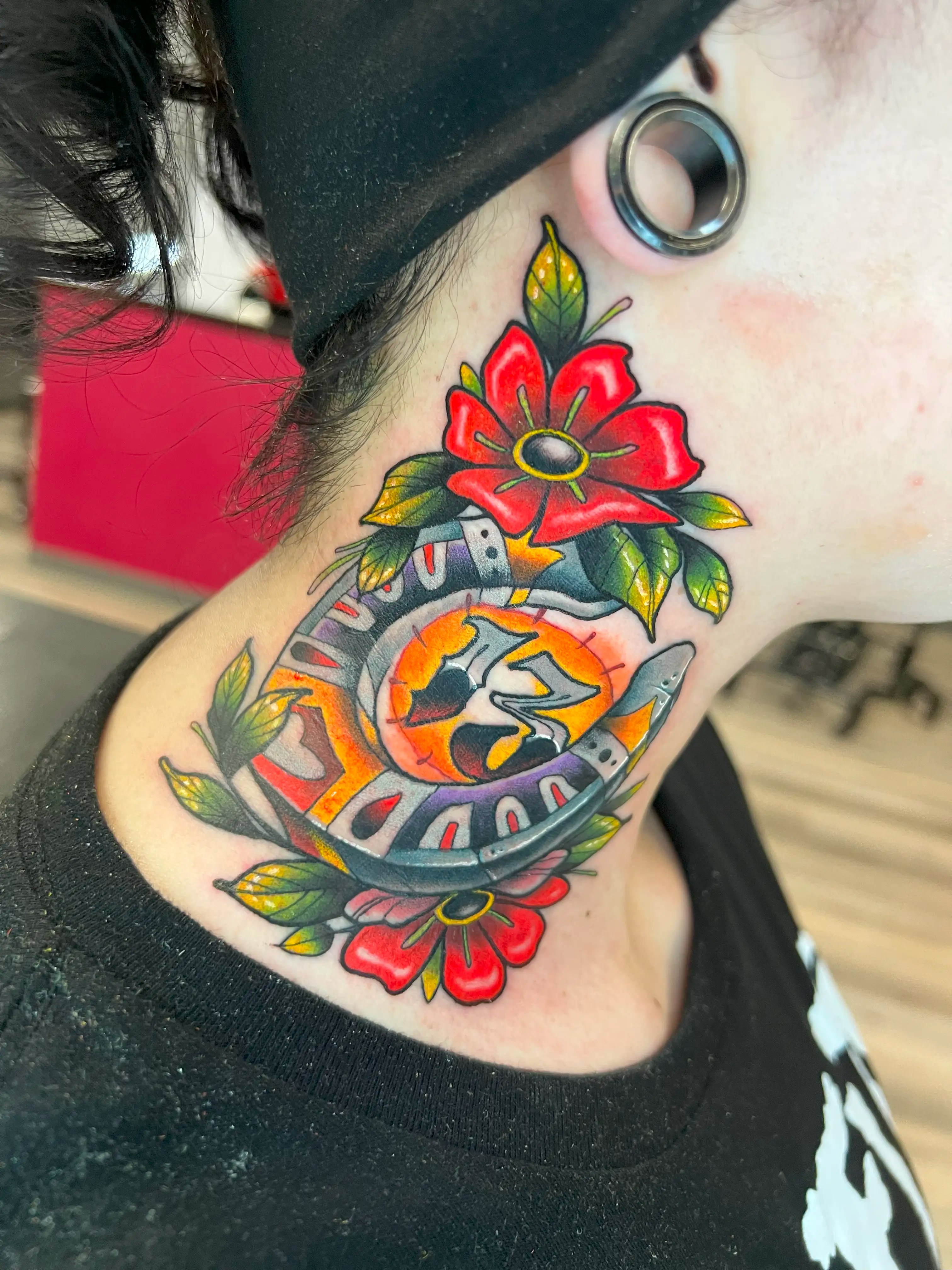 Horseshoe, flowers and the number 13 depicted in a tattoo