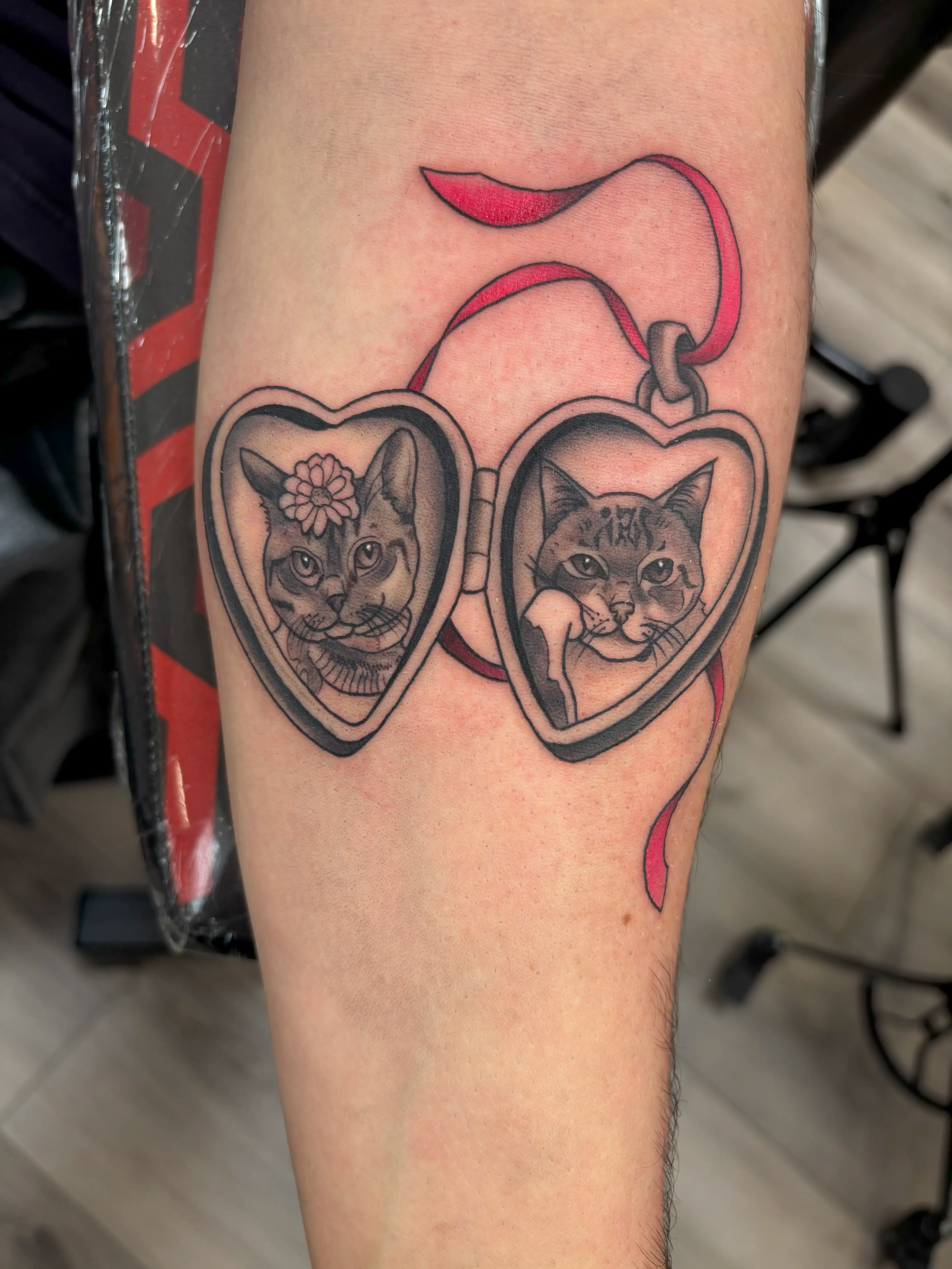 Tattoo of cat portraits in a locket