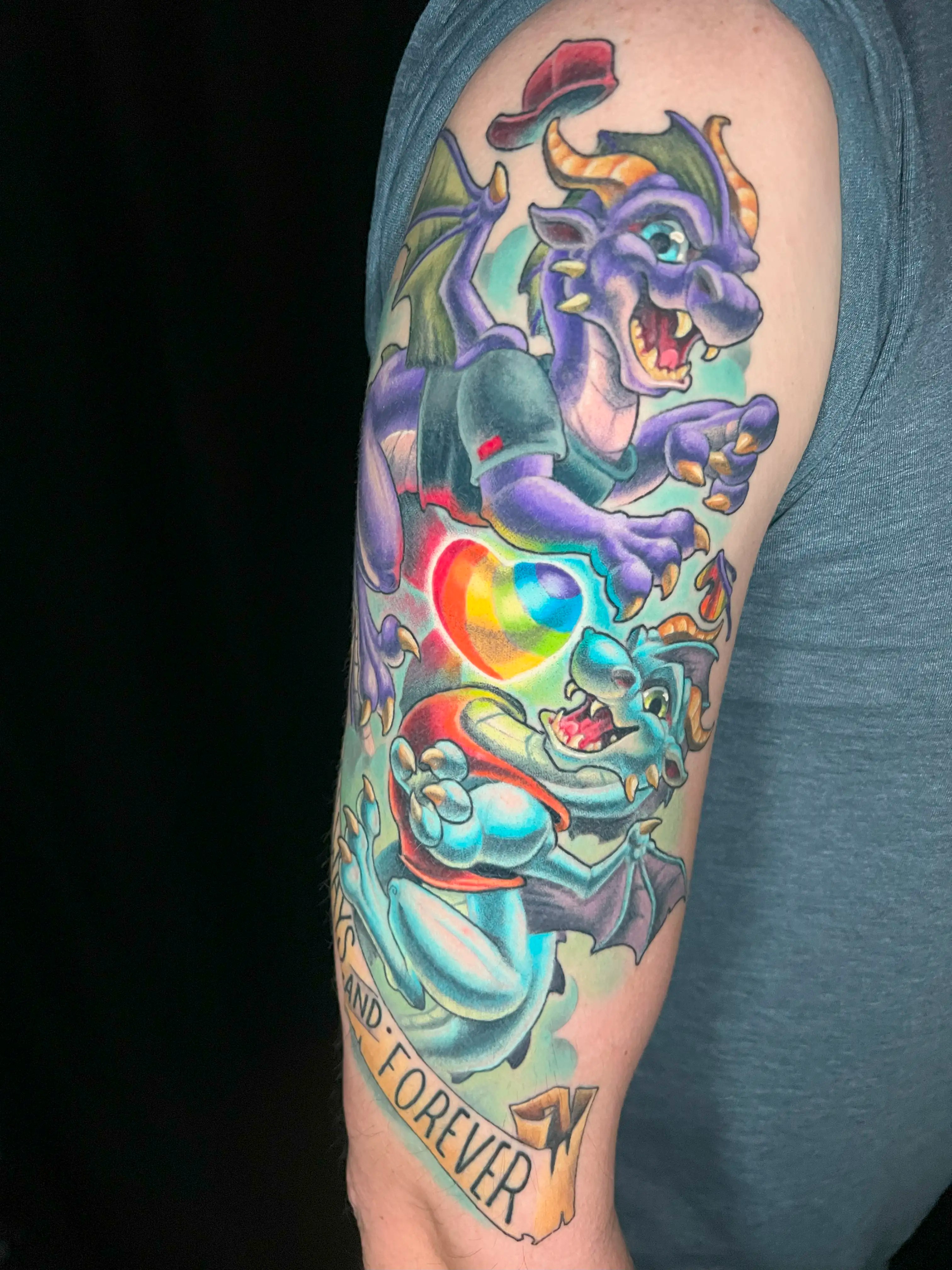 Colorful tattoo depicting two dragons and a rainbow heart